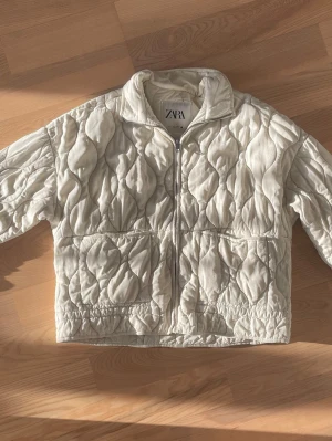 Vit quiltad pufferjacka från Zara - Säljer en vit quiltad pufferjacka från Zara!!💓 jackan har lite defekter på fickorna men inget som märks av!!💓💓