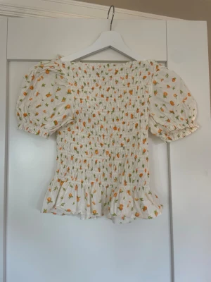 Puffärmad topp från H&M - Supersöt topp från H&M med puffärmar🩷🩷toppen har små söta apelsiner, strl XXS!!💞💞