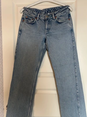 Ljusblå raka jeans med låg midja - Säljer ett par ljusblå jeans med rak passform och låg midja. Jeansen är tillverkade i kraftigt denimtyg och har en avslappnad vintagekänsla. Perfekta för en trendig och avslappnad stil. Weekday jeans. Modell Arrow 26/32