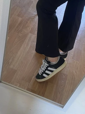Svarta Adidas campus 00s  - Säljer ett par svarta adidas campus 00s, storlek 40, dem är i bra skick, använda men dem ser ändå fotfarande riktigt bra ut när man bär på dem! Det är lite hål på insidan på tygen vid hälen på båda skorna! (Bild 6) 500kr + frakt!