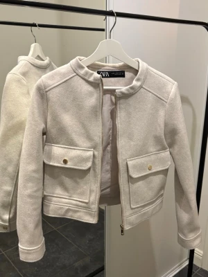 Zara spring jacket / blazer - Otroligt snygg vårjacka från Zara, ljus grå/beige med gulddetaljer. Använd 1 gång, som ny! Stl XS. Kan hämtas/skickas.