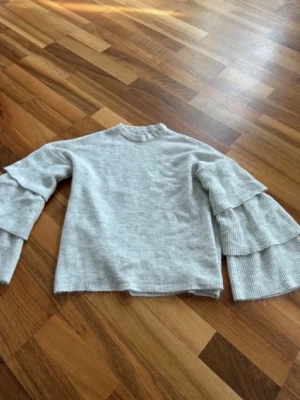 Stickad tröja med volang - Skit snygg ljusgrå stickad tröja med volang vid ärmarna!🫰❣️från only, knappt använd