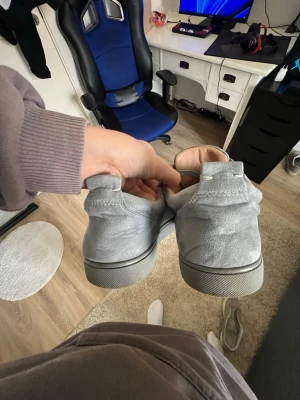 Ljusgrå sneakers med nitar - Säljer ett par ljusgrå sneakers i mocka med coola nitar på tån. Skorna har klassisk snörning och en låg siluett som passar till många olika stilar. Perfekta för dig som vill sticka ut lite extra med dina skor. Pris kan sänkas vid snabb affär