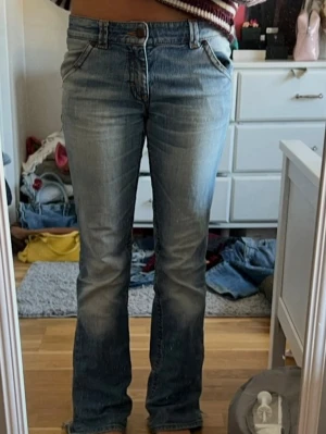 Blå bootcut jeans med slitna detaljer - Säljer ett par ljusblå bootcut jeans med lågmidja, har slitningar 