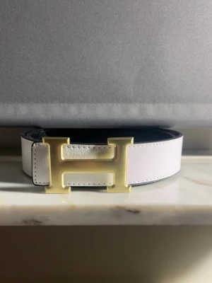 H - Bälte - • Säljer ett helt nytt, oanvänt ✅  • H - Bälte  • Vit och guldigt 🤍⚜️ • 110cm 📏 • Stilren 🔥