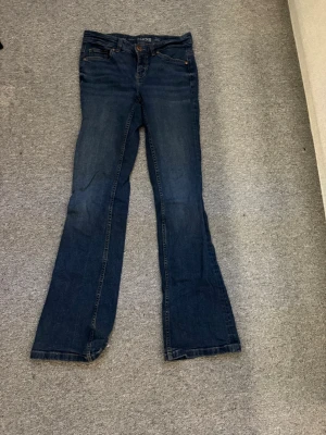 Mörkblå bootcut jeans - Säljer ett par mörkblå bootcut jeans från Kappahl. Jeansen har en lätt utsvängd passform nedtill och är tillverkade i denim. Perfekta för en avslappnad och trendig look💛
