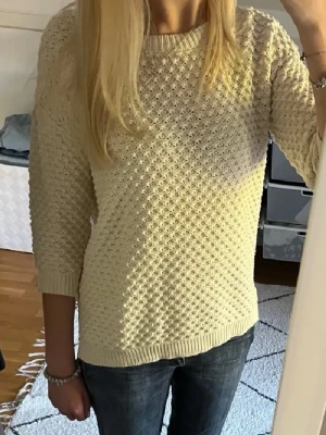Beige stickad tröja från Mango - Säljer en beige stickad tröja från Mango Basics med strukturmönster. Tröjan har rund halsringning, ribbade muddar vid ärmslut och nederkant samt en avslappnad passform. Perfekt för lager på lager och enkel att matcha.