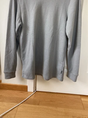 Ljusgrå ribbad tröja Only & Sons - Säljer en ljusgrå långärmad tröja från Only & Sons. Tröjan har ribbad struktur, rund halsringning och en relaxed fit. Perfekt för dig som gillar enkel och stilren design. Materialet känns mjukt och bekvämt mot huden.