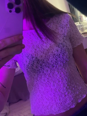 Vit spetsblus med kort ärm - Säljer en söt vit blus i spets med korta ärmar och rund hals. Blusen har ett genombrutet spetsmönster som är lätt att styla. Perfekt för dig som gillar detaljer och vill ha något extra i garderoben💞 Färgen är lite smutsvit men ska vara så och kommer inte riktigt ihåg vart den är köpt då jag klippt lappen.