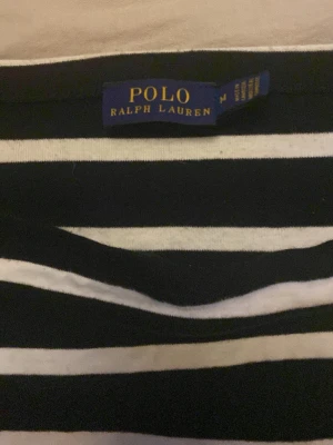 Ralph lauren tröja - En riktigt snygg svart vit randig tröja från Ralph Lauren. Tröjan är som ny och har bara används ett par gånger, tröjan är köpt för 400kr pris kan diskuteras. Hör gärna av dig om du är intresserad!!