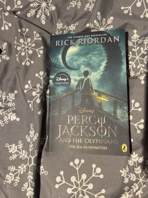 Skönlitterär bok med blått omslag - En skönlitterär bok med ett omslag i blå och svarta nyanser. Boken är i pocketformat och har en modern design på framsidan. Perfekt för dig som gillar att läsa spännande berättelser.