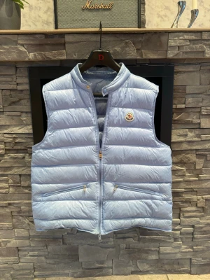 Moncler väst  - Moncler väst i den ljusblåa färgen perfekt för sommaren i storlek 4/L och sitter som L ska göra pris kan diskuteras vid smidig och trevlig affär mvh Axel 