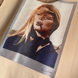 Beige hoodie Limitato x Bardot - Säljer en beige hoodie med inslag av rosa  från Limitato med Brigitte Bardot-tryck på ryggen. Tröjan har huva, dragkedja framtill och två fickor med silvriga dragkedjor. Snygga detaljer och coolt fotoprint gör den unik. Perfekt för dig som gillar streetstyle. ⚠️Box finns ⚠️