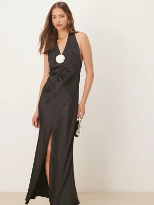 Satin klänning från Ginatricot  - Stilren svart långklänning med halterneck och djup v-ringning. Klänningen har en snygg slits framtill och en dekorativ silverfärgad detalj vid bysten. Tillverkad i glansigt satinliknande material som ger en lyxig känsla.