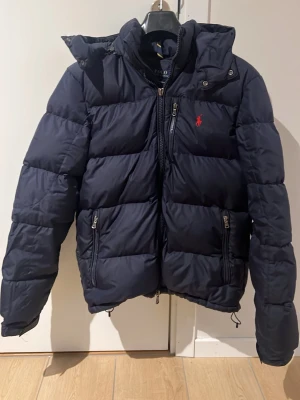 Polo Ralph Lauren jacka - Säljer nu min Ralph Lauren jacka i hyfsat skick. Säljer pga för liten. Jackan väldigt snygg och varm men har små deffekter på dragkedjan samt två små hål. Ny pris:5500 kr Mitt pris: 500. Pris kan diskuteras. 