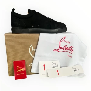 Christian Louboutin skor - Stilrena svarta sneakers i mocka från Christian Louboutin med ton-i-ton snörning och diskret logga på sidan. Skorna har en klassisk låg siluett och svart sula. Perfekta för dig som gillar exklusiv och minimalistisk design.