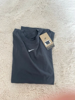 grå Nike t-shirt - En grå t-shirt från Nike med klassisk vit logga på bröstet nytt skick med lapp på 