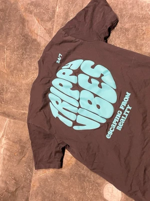 Svart t-shirt med turkost tryck - Cool svart t-shirt från Sixth June med stort turkost tryck på ryggen där det står 'Trippy Vibes' och mindre tryck på bröstet. Klassisk passform och rund hals. Perfekt för dig som gillar streetwear och grafiska prints.