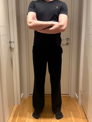 Svarta kostymbyxor med rak passform - Säljer ett par svarta kostymbyxor med rak och loose passform. Byxorna har klassisk midja och är tillverkade i ett mjukt tyg som ger en clean look. Perfekta för dig som gillar stilrena och enkla plagg.