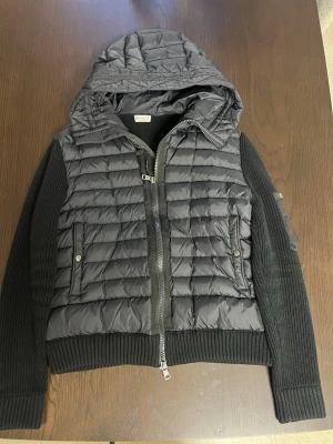Moncler Cardigan  - Säljer en schysst Moncler cardigan då den börjar sitta lite tajt. Det är en populär och klassisk padded zip-up cardigan. Som är i väldigt bra skick då den är sparsamt använd så inga tecken på slitage eller likande. Jackan är i stl L (IT50)  Vid fråger eller likande är de bara att höra av sig.                                                            Priset är ej hugget i sten!                    Billigare vid snabb affär!
