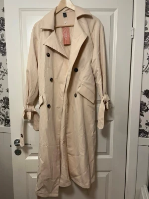Beige trenchcoat från SHEIN  - Stilren beige trenchcoat från shein med klassisk dubbelknäppning, bred krage och knytdetaljer vid ärmsluten. Bara testad :) 