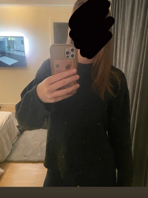 Mörkgrå stickad tröja med pärlor - Mysig mörkgrå stickad tröja med små pärldetaljer över hela tröjan. Tröjan har använt några gånger men tycker endå den är i rätt så bra skick, den sitter fortfarande bra på mig men känner att den int kommer till användning, skriv för mer info!