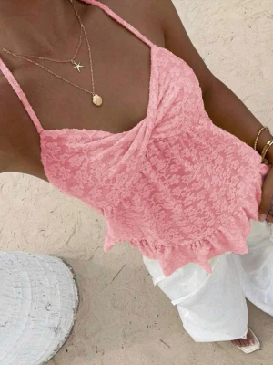 Rosa blommig spetslinnetopp - Supersöt rosa linnetopp med blommigt spetsmönster och volangkant nedtill. Toppen har tunna axelband som knyts i nacken och en lätt rynkad detalj vid bysten. Perfekt för varma dagar och ger en romantisk vibe till din outfit. Skit snygg🥰🥰