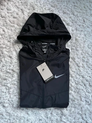 Svart Nike windbreaker - Snygg svart nike windbreaker i storlek S. Perfekt nu till våren. Fraktar samma dag som köp! 