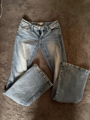 Ljusblå bootcut jeans från GinaTricot - Säljer ett par ljusblå bootcut jeans från ginatricot! Jeansen har detaljerad ficka med paljetter. Jeansen är lågmidjade.