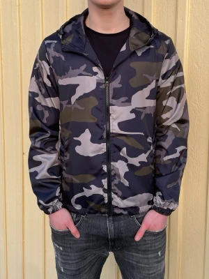 Camo windbreaker - Säljer en sprillans ny woolrich liknande camo windbreaker för endast 399kr. Jackan fungerar perfekt nu inför de kommande vädret och man kan även justera passformen på insidan. Har 3 olika storlekar, S,M och L Hör av er vid minsta fundering.