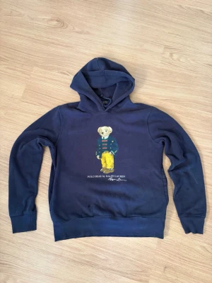 Ralph lauren polo bear hoodie - En blå Polo Ralph hoodie med polo bear tryck.  Den är i bra skick och storlek S. Hör av dig vid frågor