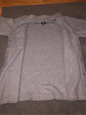 Grå overshirt i ullmix - Snygg grå overshirt från Lindbergh i mjuk ullmix. Rak passform med tryckknappar framtill och på ärmsluten. Två bröstfickor ger en clean look. Perfekt lager-på-lager-plagg för kyliga dagar.