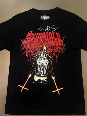 Svart signerad Sematary   - Signerad: av sematary svart t-shirt från Sematary med tryck fram i rött och vitt, samt text 'Haunted Mound Forever' och en ängel på ryggen. Perfekt för dig som gillar alternativ stil och streetwear.