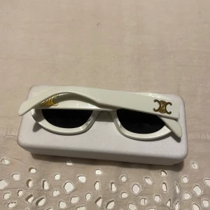 Vita solglasögon från Celine  - Snygga vita solglasögon från Celine Paris, modellen Triomphe 01. Bra skick men lite använda, dock inget märkbart! Säljer pga kommer inte till användning längre. Pris går självklart att diskutera🌟🌟