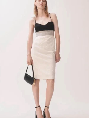 Studentklänning Svart och vit klänning med smala band - Säljer en elegant klänning med svart överdel, smala axelband och vit kjoldel. Den perfekta studentklänningen. Klänningen har en markerad midja med ett ljust band och är knälång. Perfekt för dig som gillar stilrena kontraster och enkel design. Designer arkisklänning från Narciso Rogeigues. Du kommer utmärka dig med denna klänning på din största dag i livet på studentdagen. Säljes för samma pris som jag köpte den för. 