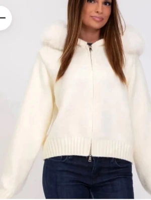 Vit hoodie med fuskpäls på huvan - Mysig vit hoodie med dragkedja och stor huva kantad med fluffig fuskpäls. Aldrig använd