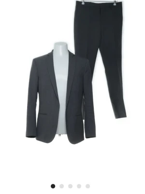 Kostym - stilren & klassisk (kavaj + byxor) - Kostym - stilren & klassisk (kavaj + byxor)  Säljer en snygg och tidlös kostym i mörk färg. Perfekt för fest, jobb, student eller andra tillfällen där du vill se välklädd ut.  Skick: Bra använt skick  Detalj: Mindre hål på insidan (syns inte utåt och påverkar inte utseendet)  Passform: Slim fit Färg: Mörkgrå Material: Bekvämt och stilrent tyg  Kostymen sitter snyggt och funkar till både formella och semi-formella tillfällen.  Pris: 499  Frakt: Snabb leverans