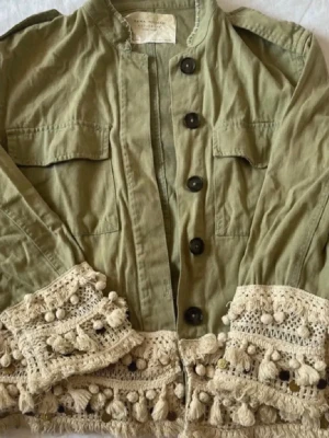 Grön jacka med virkade detaljer - Säljer denna gröna jacka från Zara då den inte kommer till användning längre. Den är super fin och har inga fel❣️den är i storlek M men jag som har XS passar den super bra på