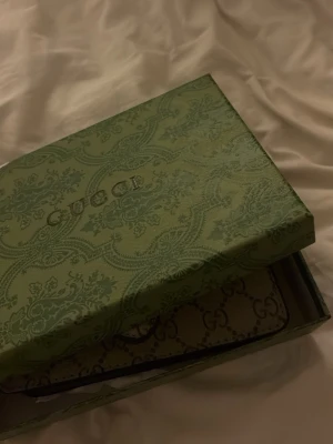 Gucci Dionysus GG Supreme handväska - Snygg handväska från Gucci i beige GG Supreme canvas med klassiskt monogrammönster. Väskan har silverfärgat spänne i form av ett tigerhuvud och detaljer i ljusbrunt läder. Kedjerem i metall för axelbärning. Perfekt för dig som gillar lyxiga accessoarer.