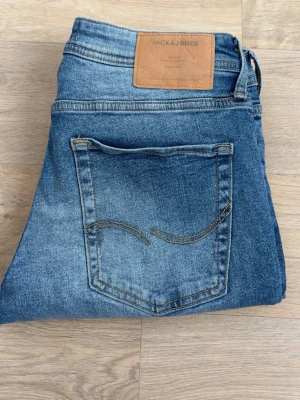 Blå slitna jeans från Jack & Jones - Säljer ett par blå jeans från Jack & Jones med slitningar och hål på benen.                                              Storlek: 29/32 👍🏼                                                                  Vid frågor och funderingar, hör av er 😇
