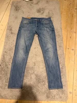 Dondup jeans - Snygga blå slim fit jeans med klassisk femficksdesign och lätt slitna detaljer. Jeansen har normal midja och raka ben, perfekta till vardagslooken. Tillverkade i mjukt denimtyg för skön känsla.