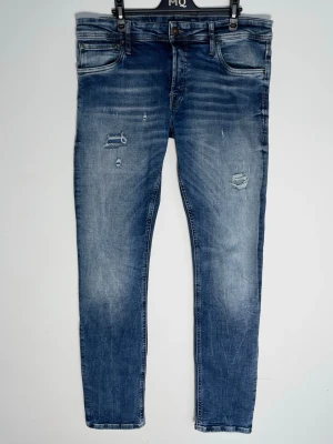 Jack and Jones jeans med slitningar - Jack&jones jeans i en riktigt fet tvätt med feta slitningar! Fint skick inga tydliga defekter. Slim glenn och modellen är ca 180, 70 kg. Storlek 32/32. Kontakta mig för fler frågor och funderingar!