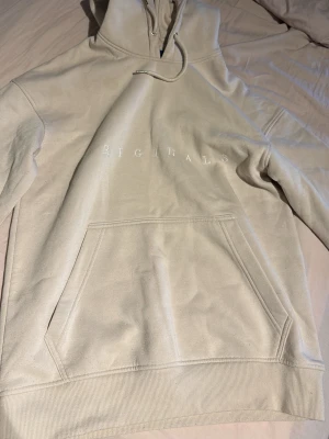  hoodie från Jack & Jones - Snygg  hoodie från Jack & Jones med broderad text 'ORIGINALS' på bröstet. Klassisk känguruficka framtill, huva med dragsko och ribbade muddar. Perfekt för en chill och avslappnad stil.