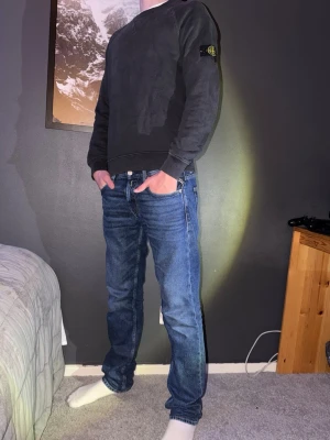 Svart sweatshirt från Stone Island - Säljer en svart sweatshirt från Stone Island med klassisk logga på vänster ärm. Tröjan har rund hals, ribbade muddar och är tillverkad i mjuk bomull. Storlek XS. Han på bilden är 177. Knappt använd. Går att jag köpa för bättre pris med ett par jeans från min sida Ny pris 1700 kvito finns