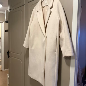 Ljusbeige kappa med knappar - Beige kappa från H&M som fungerar perfekt under höst/vinter. Delar av kappan är nopprig och har lite små fläckar (se bilder). Oversized i modellen.🤎 Fodrad insida för extra komfort.