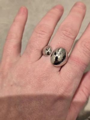 Silverring med pärlor - Säljer en elegant silverring med små vita pärlor som dekoration. Ringen har en klassisk rund form och pärlorna är jämnt placerade runt hela ringen för en stilren look. Perfekt för dig som gillar tidlösa accessoarer med en twist.