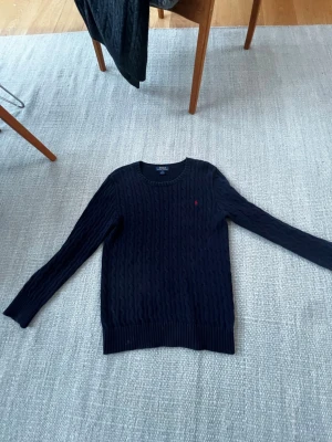 Ralph Lauren kabelstickad str 18-20 - Kabelstickad Ralph Lauren tröja använd men inte defekter skick 8/10. I största barnstorleken. Hör av dig om du har frågor!