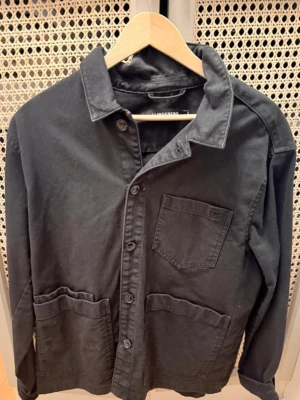 Svart overshirt från J.Lindeberg  - Stilren svart overshirt från J.Lindeberg knappt använd 