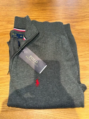 Ralph lauren quarterzip (M) Ny-oanvänd  - Säljer en helt ny och oanvänd Ralph Lauren quarter zip i stilren mörkgrå färg. Nypris - 2499. Hör gärna av dig vid frågor!