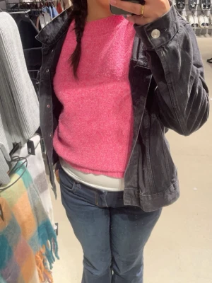 Rosa stickad tröja - Säljer en snygg rosa stickad tröja med rund hals och rak passform. Tröjan har en mjuk struktur och är perfekt att matcha med jeans eller kjol. Enkel men färgstark design som ger en poppig look.